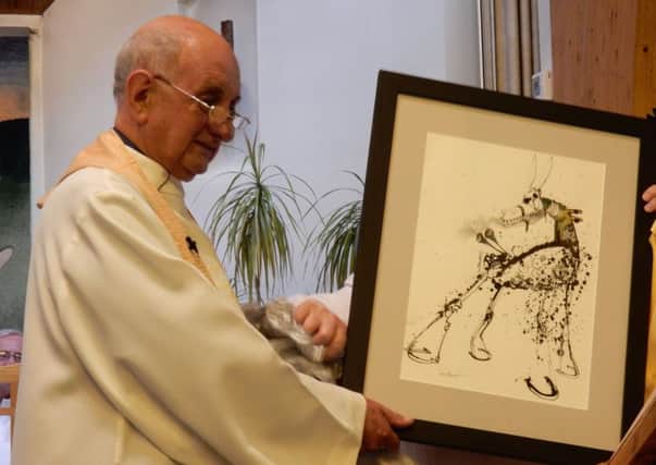 Father John Gott being presented with a pianting by local artist Louie Benoit