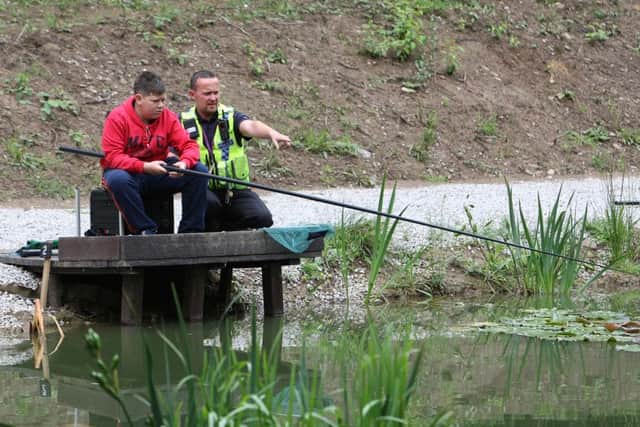 Police organising fishing for kids at Brookfoot, Brighouse. PC Chris Madden with Callum Tyley 13