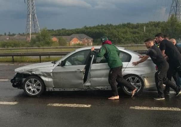 Harrogate Railway players push their battered car on the M62 (Source: Twitter)