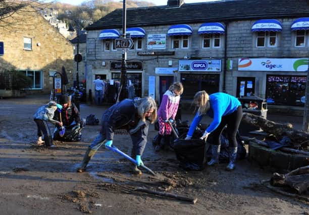 Volunteers clean up the centre of Hebden Bridge after the Boxing Day floods.