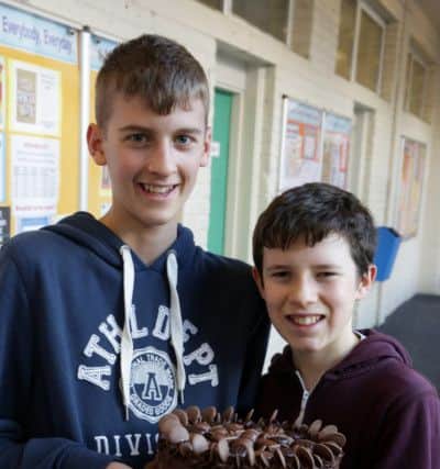 Calderdale school fund raise for the flood victims. Dave Fleet and Kyran Lewis, aged 13 and 14, with their chocolate cake auction at Calder High School, Mytholmroyd.
