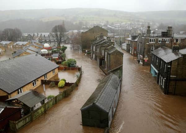 MYTHOLMROYD, ENGLAND - DECEMBER 26:  The River Calder bursts its bank's in the Calder Valley town of Mytholmroyd on December 26, 2015 in Mytholmroyd, England. There are more than 200 flood warnings across Britain as home and business owners prepare for serious flooding. The army has been deployed to some villages to bolster flood defences as rain continues to fall across the north.  (Photo by Christopher Furlong/Getty Images)