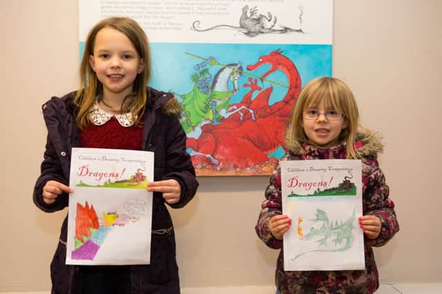 Skylar and Aurelia Falconer with their dragon drawings, at Brighouse Library for the National Library Day