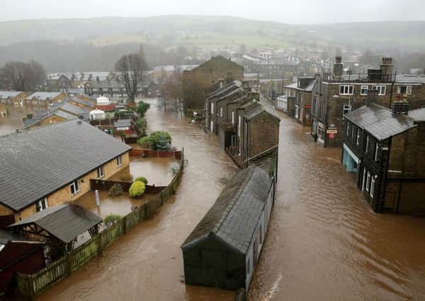 MYTHOLMROYD, ENGLAND - DECEMBER 26:  The River Calder bursts its bank's in the Calder Valley town of Mytholmroyd on December 26, 2015 in Mytholmroyd, England. There are more than 200 flood warnings across Britain as home and business owners prepare for serious flooding. The army has been deployed to some villages to bolster flood defences as rain continues to fall across the north.  (Photo by Christopher Furlong/Getty Images)