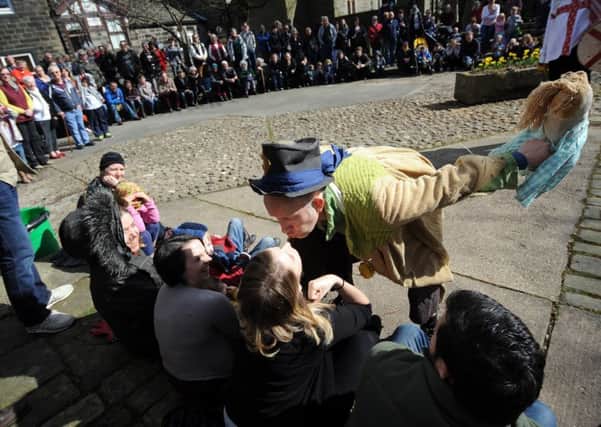 Pace Egg Play, Weavers Square, Heptonstall. The Fool kisses one of the public watching.25th March 2016 ..Picture by Simon Hulme