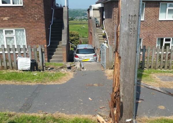 A car veered off the road and was wedged between two houses on Fairfax Crescent, Southowram.