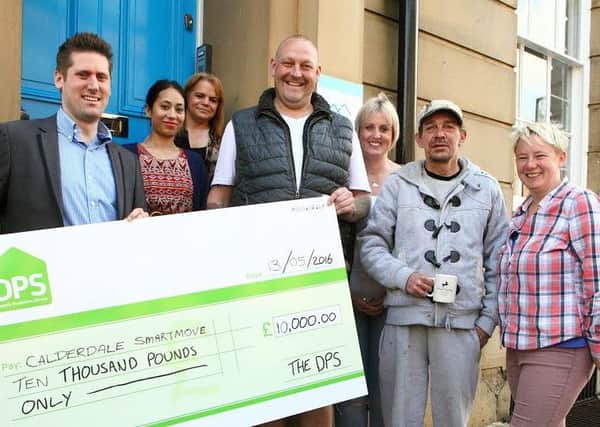 Chris Leonard, Senior Business Manager at The Deposit Protection Service (The DPS) (left), Craig George, Fundraising and Relationship Manager at Calderdale Smartmove (centre) with staff members and service users outside the charitys offices in Halifax.