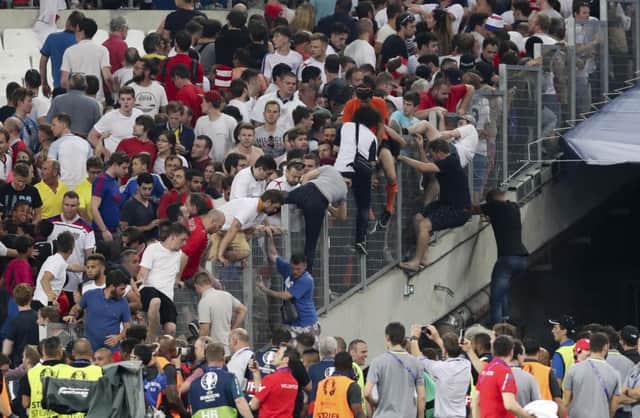 Spectators try to escape from the stands as clashes break out right after the Euro 2016 Group B soccer match between England and Russia, at the Velodrome stadium in Marseille