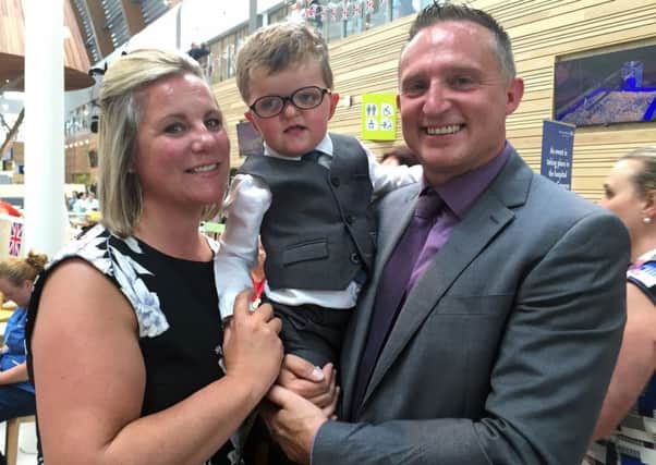 Three-year-old Lewis Connett, who was diagnosed with Apert Syndrome when he was a baby, with his parents Donna and John after he gave the Queen a posy during her visit to officially open the new Alder Hey Children's Hospital.