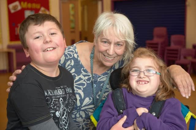 Janet Wilby, senior administrator at Woodbank School, Luddenden, retires after 31 years. With Janet are pupils Harry Critchlow aged ten and Phoebe Hoyle aged nine.