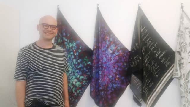 Dr Steve Bagley with scarves showing his research at the exhibition