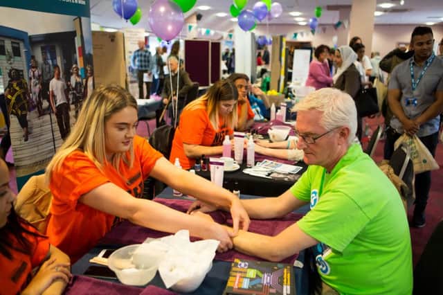 Stacie Holliday, student at Calderdale College, gives a hand massage to Declan Brewer, during the World Mental Health Day event, at the Shay, Halifax