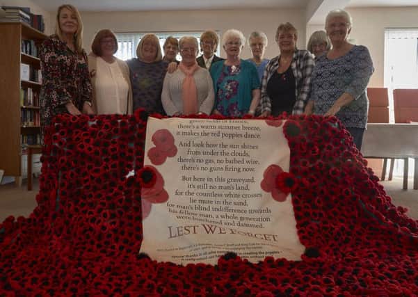 Crocheters with their poppy blanket at Hanover House, Sowerby Bridge.