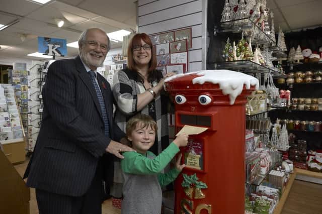Five-year-old Edward Lee posts his Christmas list watched by his mum Tracy Harvey and grandad Roger Harvey