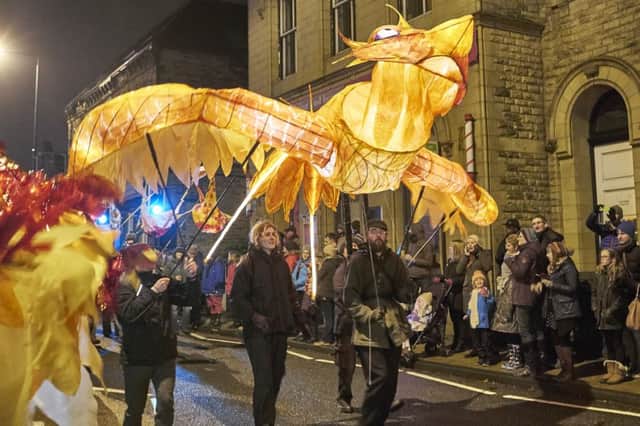 Todmorden Lamplighters Feastival lights up the street on a parade through the town centre.