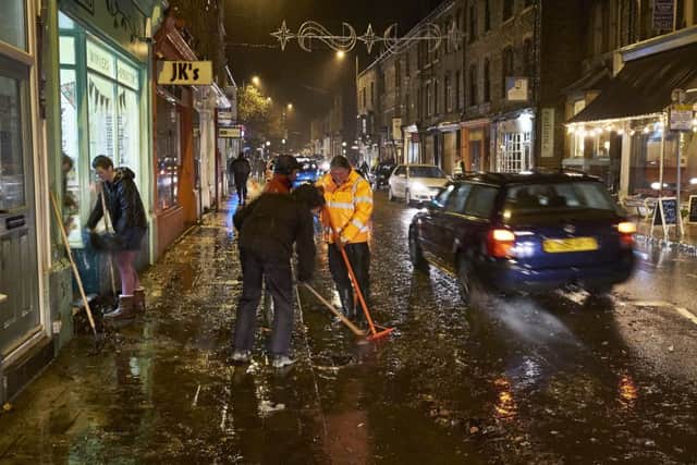 Businesses in Market Street, Hebden Bridge fight back the flood water from Monday's downpour.