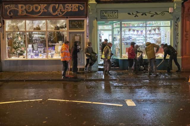 Businesses in Market Street, Hebden Bridge fight back the flood water from Monday's downpour.