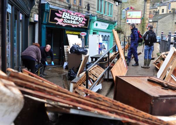 Volunteers clean up the centre of Hebden Bridge  outside the flooded premises.  Picture Tony Johnson