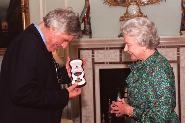 The Queen invests Poet Laureate, Ted Hughes, with the insignia of a Member of the Order of Merit, at Buckingham Palace.