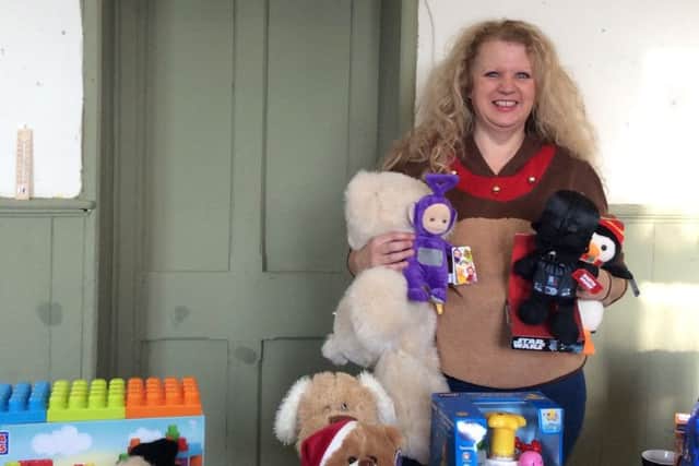 Sowood WI's President Jackie Swire with arms full of donated gifts