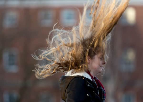 A young lady loses the control of her hair in the strong winds around Bridgewater Place. PIC: James Hardisty