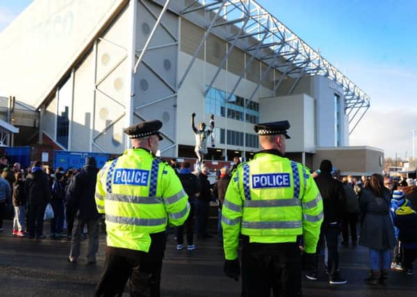 Police keep watch of the Leeds fans by the Billy Bremner statue outside Elland Road. Picture by Tony Johnson
