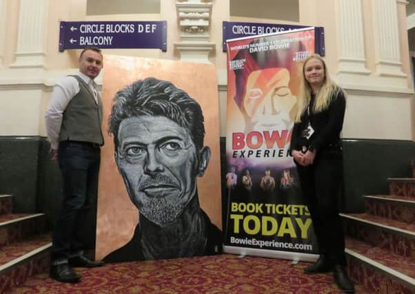 Carl Hopkins with his painting at the Victoria Theatre