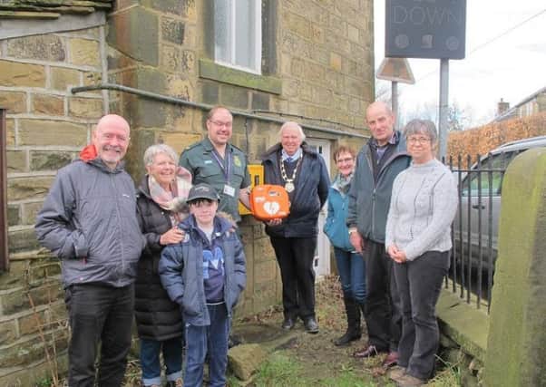 John Spikings from Yorkshire Ambulance Service (centre), launching the defibrillator at Blackshaw Methodist Chapel, with Edith Bowman (second left), Chairman of Blackshaw Parish Council, Roger Butterworth (centre) and other residents.
