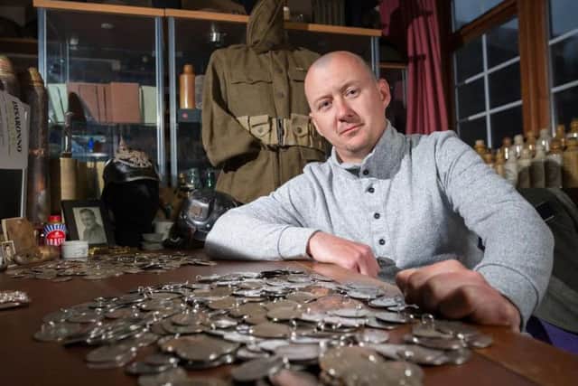 Dan Mackay with the dog tags he found buried in a field.