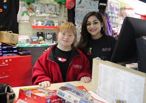 Volunteer Natalie working in the Eureka! Gift Shop with Enabler Aisha Shaffiq