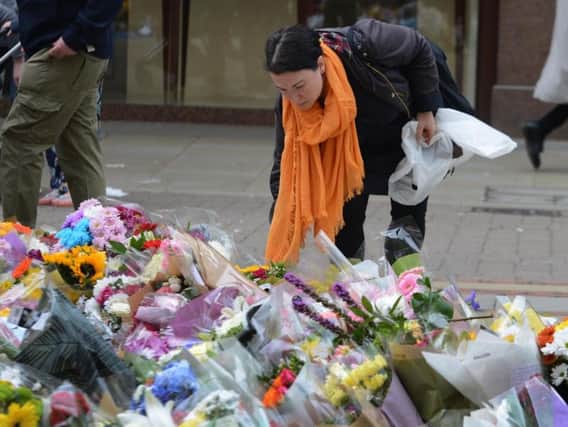 Mourners look put down flower tributes at St Ann's Square in Manchester city centre. Pic: SWNS