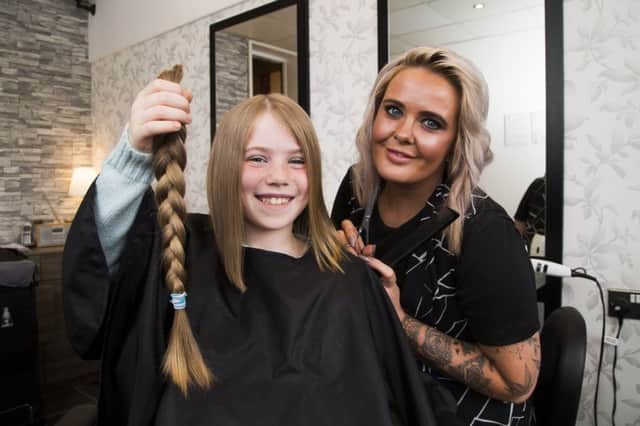 Anya Buglass-Frazer, nine, has her hair cut for the Little Princess Trust, by Envy Hair and Nail Studio owner Emma-Jane Pierson.