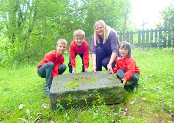 Head teacher Kate Lambert and pupils by the time capsule they dug up to display at the celebration evening