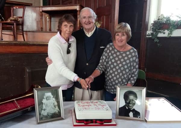 Best wishes, Geoff: Bill Birch cuts the centenary cake, donated by Oddies, with Geoffs daughters-in-law Diana Love, left, and Rosalind Love