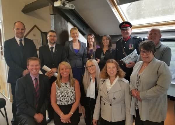 Proud: From the left, back, Colin Smart (senior partner), Simon Pennells (senior partner), Helen Parsons (partner), Natalie McDermott, Marie Bradley (partner), Deputy Lord Lieutenant of West Yorkshire Major Hardy and Paul Brown and, front,  James Boyd, Jacqui George, Amber Fermoyle, Alison Smart and Theresa Bright