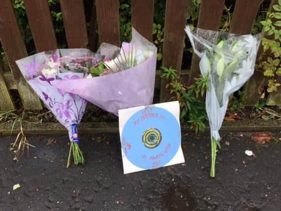 Floral tributes outside the scene in Mixenden Road