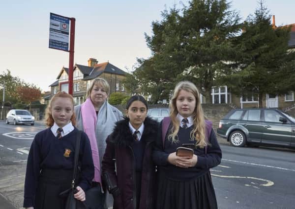 Vanessa Casey with her daughter Lauren, aged eleven, and her friends Imaan Fazal 11 and Grace Kenyon 11 at the bus stop in Skircoat Green.