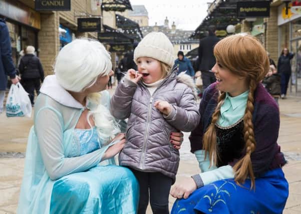 Aubrey Ambler, three, with Jade Wright as Elsa, left, and Jordan Garnett as Anna, right,  the snow princesses
