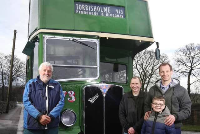 Darren Hunt (extreme right) and his friend John Hewitt (second right) with the bus they jointly own and have rebuilt.
