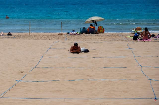 Tourists already have to stay within one of 5,000 13 by 13 feet squares marked out on the popular Poniente and Levante beaches (Photo by JOSE JORDAN/STR/AFP via Getty Images)